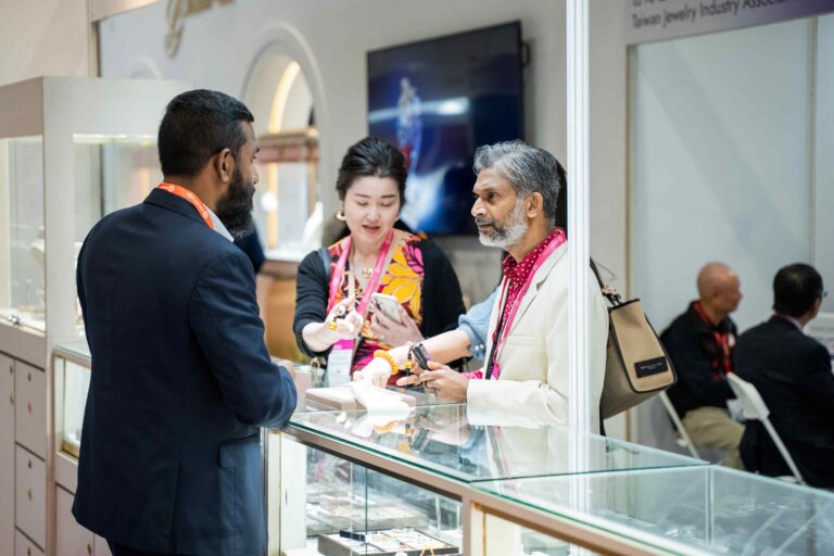 Exhibitor presenting jewellery pieces to international buyers at Jewellery & Gem Fair Taiwan 2026.