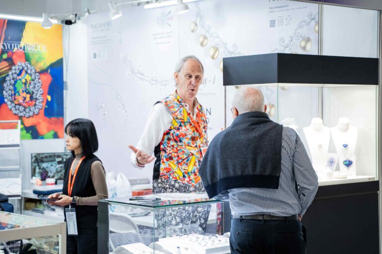 Exhibitor discussing jewellery designs with visitors at Jewellery & Gem Fair Taiwan 2026.